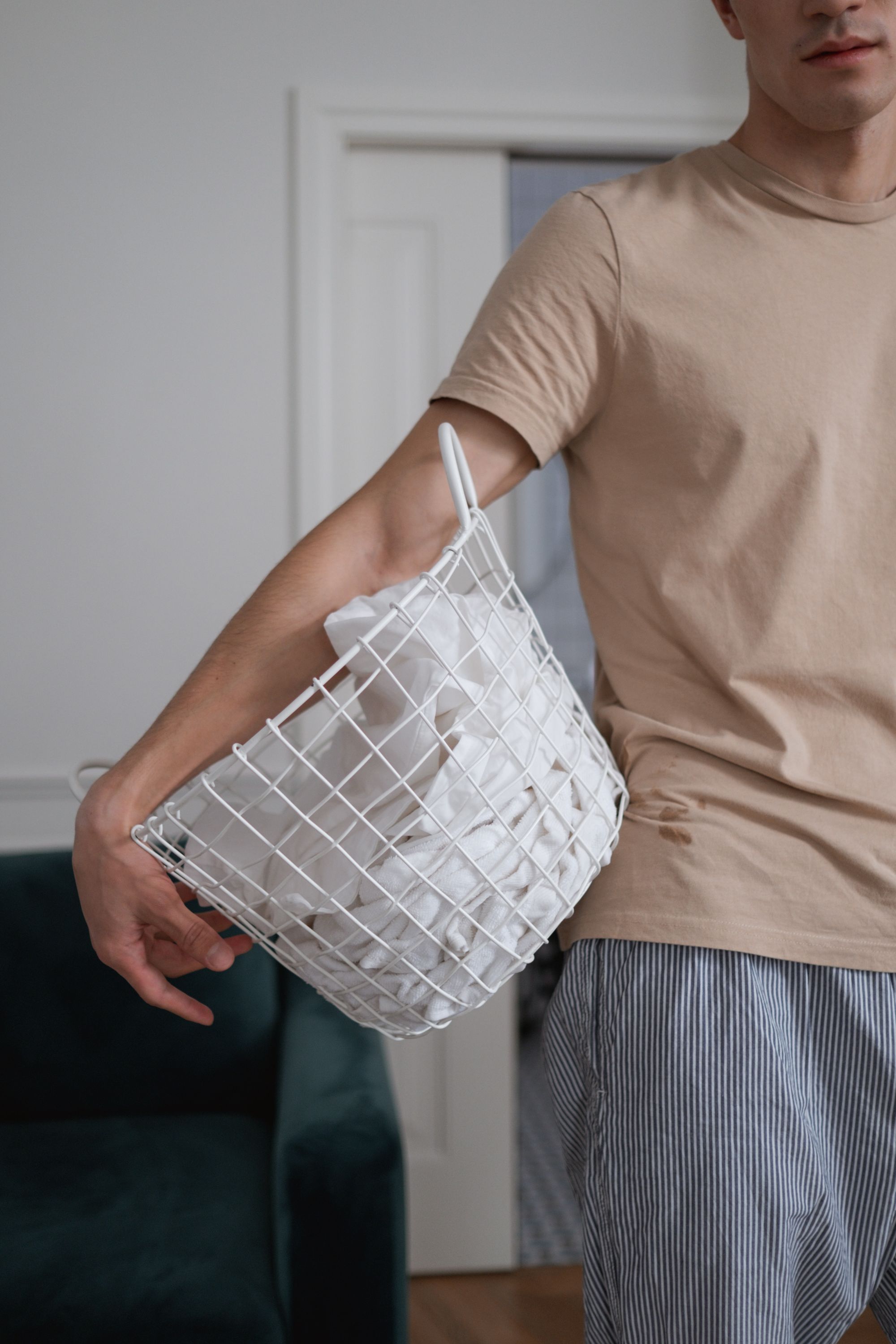 man carrying a basket of white article of cloth
