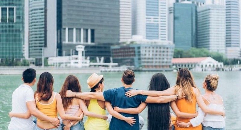 group of friends hugging in front of Fullerton Bay hotel